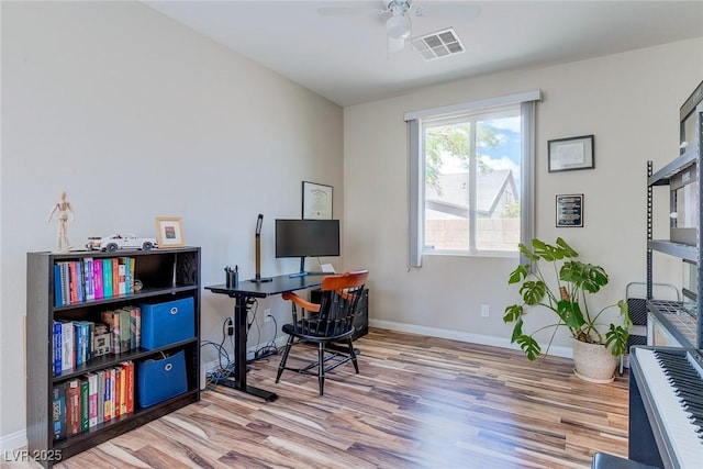 office with baseboards, ceiling fan, wood finished floors, and visible vents