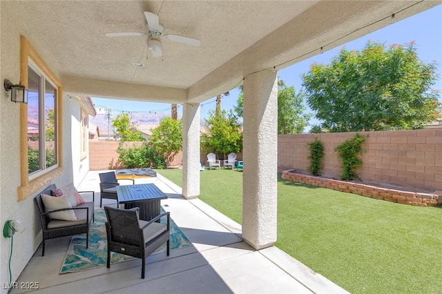 view of patio / terrace with an outdoor living space, a fenced backyard, and ceiling fan