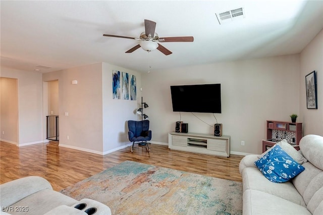 living room with baseboards, a ceiling fan, wood finished floors, and visible vents