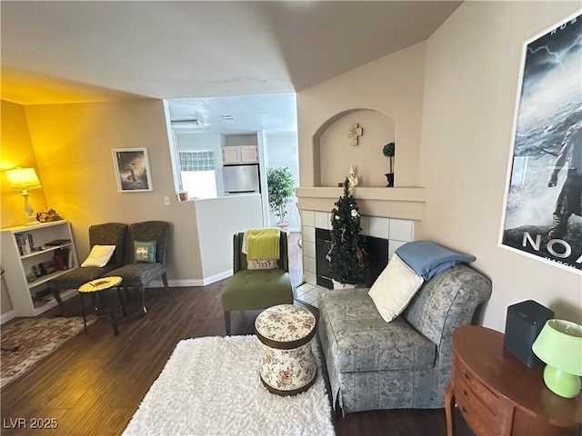 698 S Racetrack Rd Unit 322, Henderson, NV 89015 - living room with a tiled fireplace, baseboards, and wood finished floors
