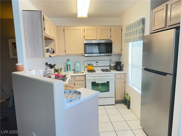 698 S Racetrack Rd Unit 322, Henderson, NV 89015 - kitchen with light countertops, light tile patterned floors, a sink, a peninsula, and stainless steel appliances