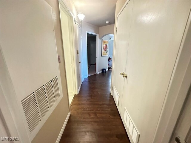 698 S Racetrack Rd Unit 322, Henderson, NV 89015 - hall with arched walkways, a heating unit, baseboards, visible vents, and dark wood-style floors