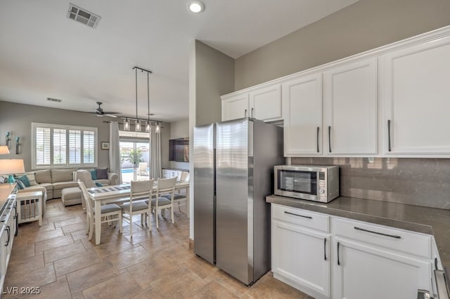 kitchen featuring appliances with stainless steel finishes, white cabinetry, open floor plan, a ceiling fan, and visible vents