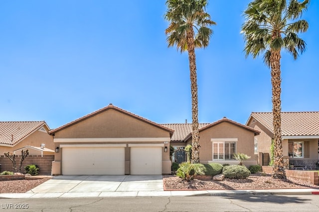 view of front of home featuring a tiled roof, an attached garage, concrete driveway, and stucco siding