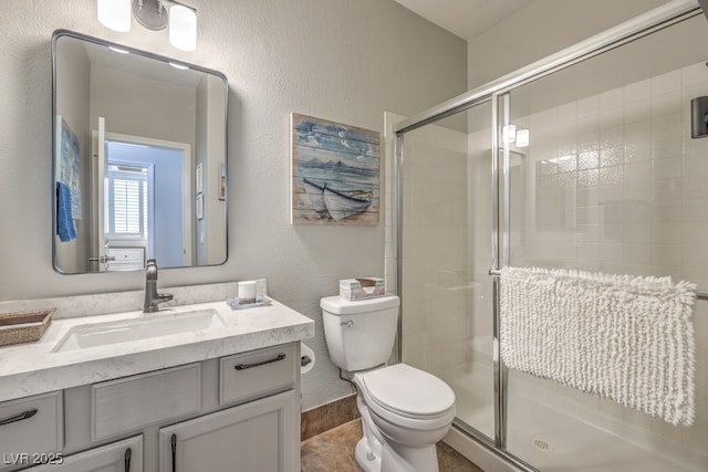 full bath featuring vanity, a shower stall, and toilet
