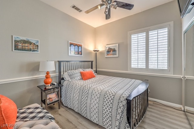 bedroom with baseboards, visible vents, multiple windows, and wood finished floors