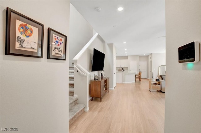 hall with recessed lighting, baseboards, stairs, and light wood-style flooring