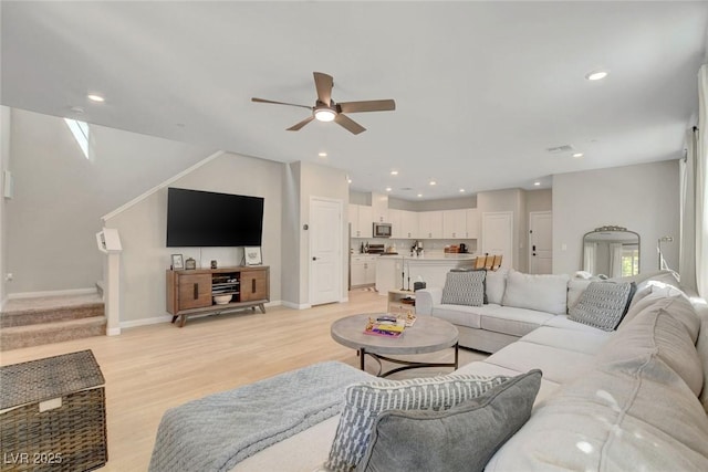 living area with stairs, light wood-style floors, baseboards, recessed lighting, and a ceiling fan