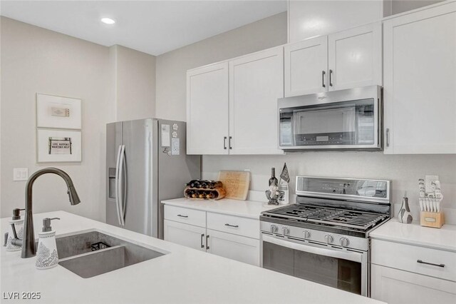 kitchen with light countertops, a sink, white cabinetry, and stainless steel appliances