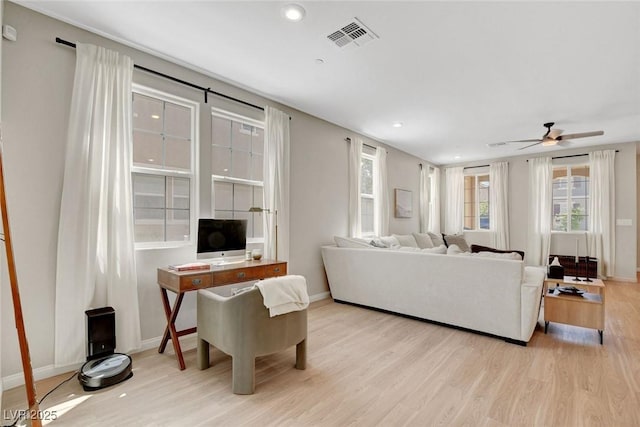 living area with a ceiling fan, baseboards, recessed lighting, wood finished floors, and visible vents