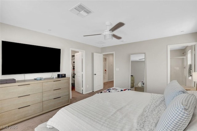 bedroom featuring a walk in closet, light colored carpet, visible vents, baseboards, and a closet