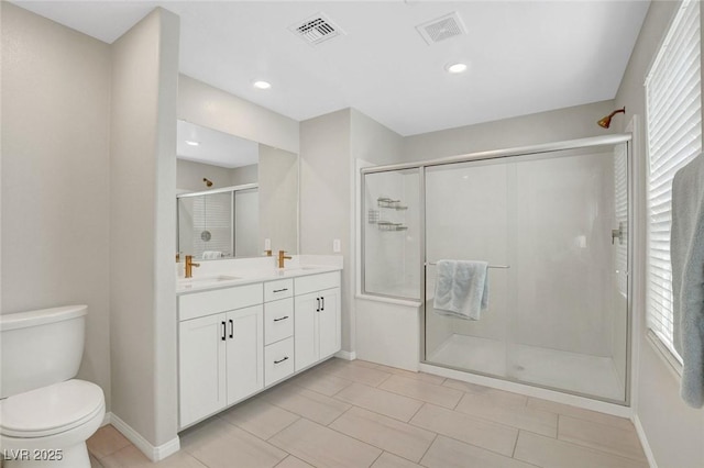 bathroom with visible vents, double vanity, toilet, and a shower stall