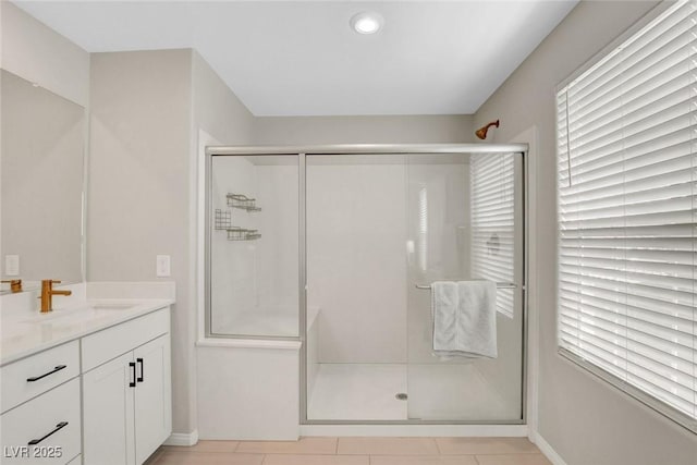 bathroom featuring a stall shower, vanity, baseboards, tile patterned floors, and recessed lighting