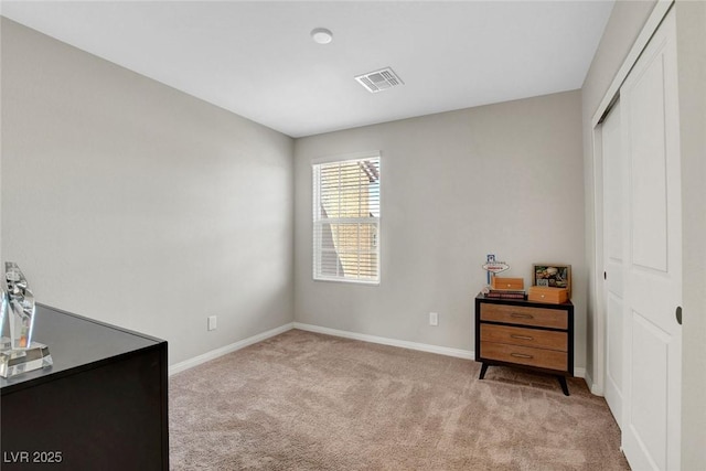 unfurnished bedroom with baseboards, visible vents, carpet, and a closet
