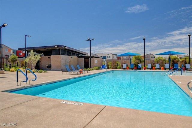 pool featuring fence and a patio area