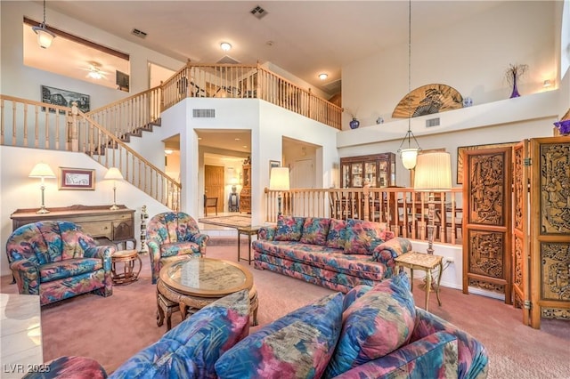 living room with carpet flooring, high vaulted ceiling, stairs, and ceiling fan