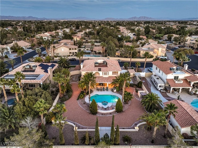 aerial perspective of suburban area featuring a pool area and mountains