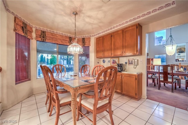 dining room with light tile patterned flooring, a chandelier, and light carpet
