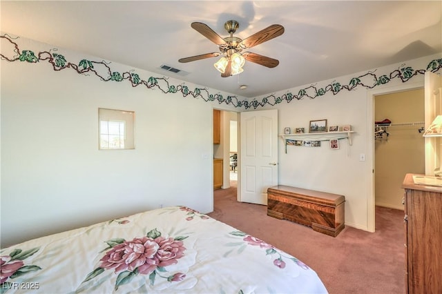 bedroom with carpet floors, a walk in closet, baseboards, a ceiling fan, and a closet