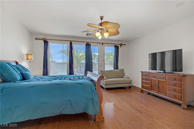 bedroom with light wood finished floors, access to exterior, a ceiling fan, baseboards, and visible vents