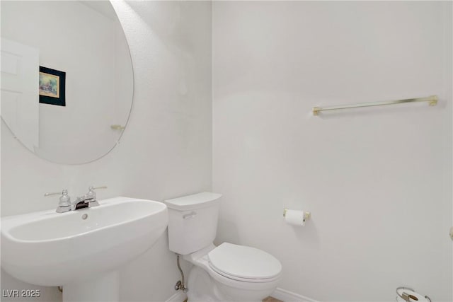 bathroom with baseboards, a sink, and toilet