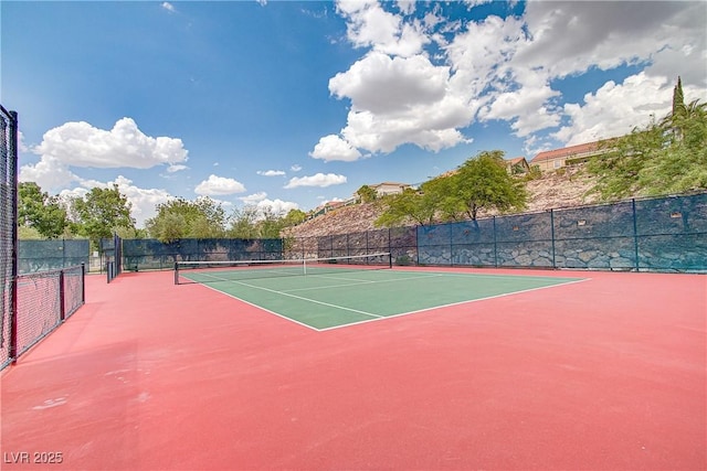 view of tennis court with community basketball court and fence