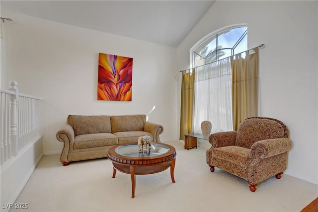 living room featuring carpet floors, baseboards, and vaulted ceiling