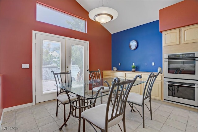 dining space with french doors, high vaulted ceiling, baseboards, and light tile patterned floors