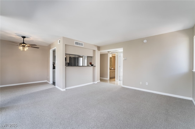 unfurnished living room featuring visible vents, baseboards, ceiling fan, and light colored carpet