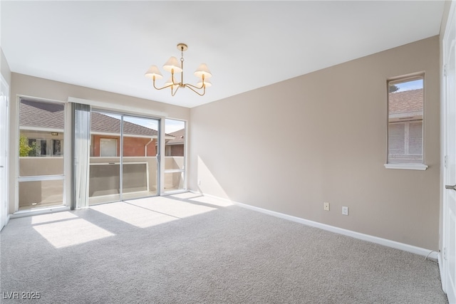 carpeted spare room featuring baseboards and a notable chandelier