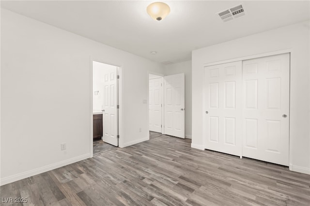 10525 Shiny Skies Dr, Las Vegas, NV 89129 - unfurnished bedroom featuring baseboards, wood finished floors, ensuite bathroom, visible vents, and a closet