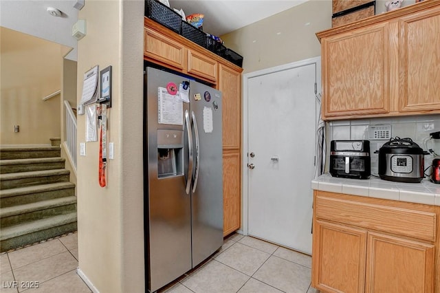 1007 Shades End Ave, North Las Vegas, NV 89081 - kitchen featuring stainless steel fridge with ice dispenser, tile countertops, light tile patterned floors, and backsplash