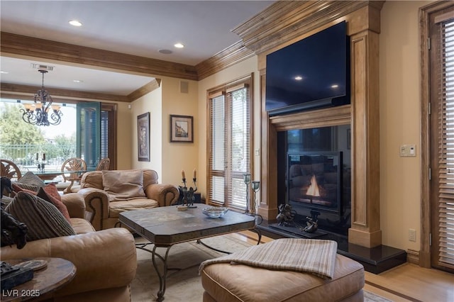 living room with crown molding, recessed lighting, light wood-style floors, and a notable chandelier