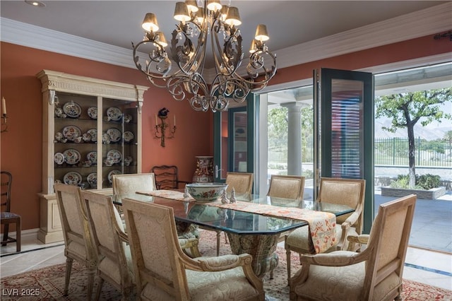 dining area with an inviting chandelier, crown molding, and light tile patterned floors