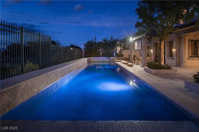 view of pool featuring a patio, fence, and a pool with connected hot tub