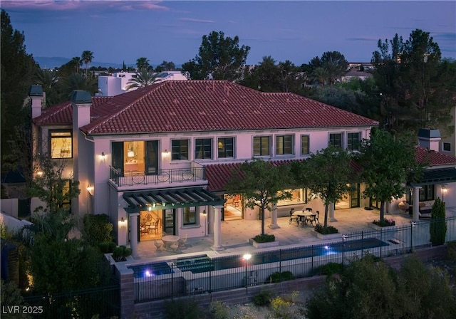 back of property featuring a patio, fence, a tile roof, and stucco siding