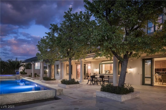 rear view of property featuring stucco siding and a patio area