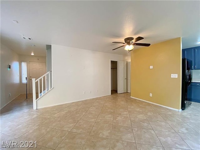 unfurnished living room with visible vents, stairs, baseboards, a ceiling fan, and light tile patterned floors