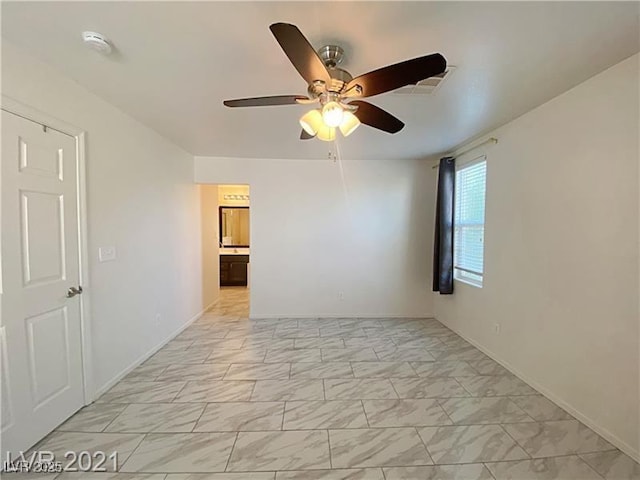 spare room featuring visible vents, a ceiling fan, marble finish floor, and baseboards
