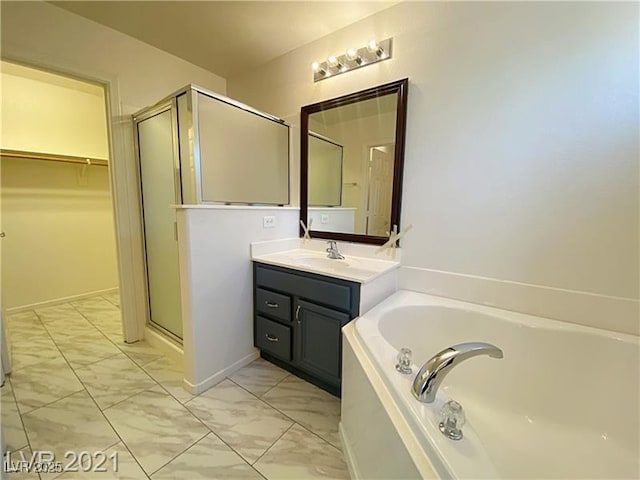 bathroom with vanity, marble finish floor, a bath, a spacious closet, and a stall shower