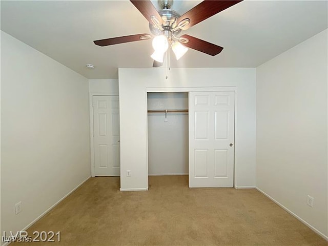 unfurnished bedroom featuring a ceiling fan, baseboards, light colored carpet, and a closet