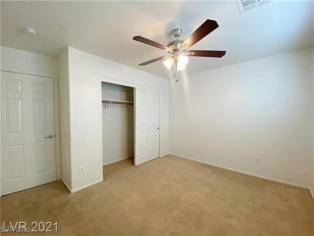 unfurnished bedroom featuring visible vents, a closet, baseboards, ceiling fan, and light colored carpet