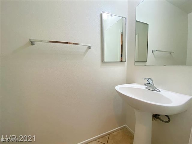 bathroom with baseboards and tile patterned flooring