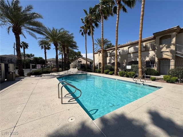 community pool with a patio and fence
