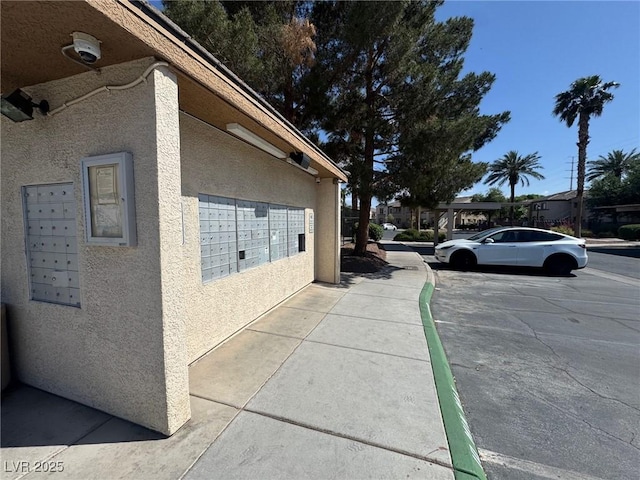 view of home's exterior with stucco siding and mail area