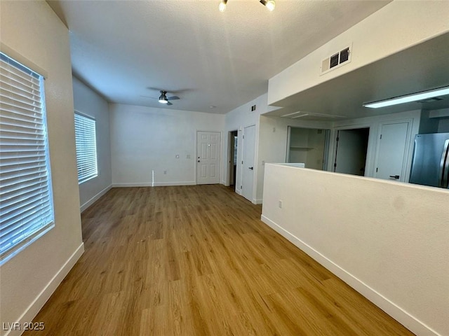 3400 Cabana Dr Unit 1033, Las Vegas, NV 89122 - unfurnished living room with ceiling fan, wood finished floors, baseboards, and track lighting