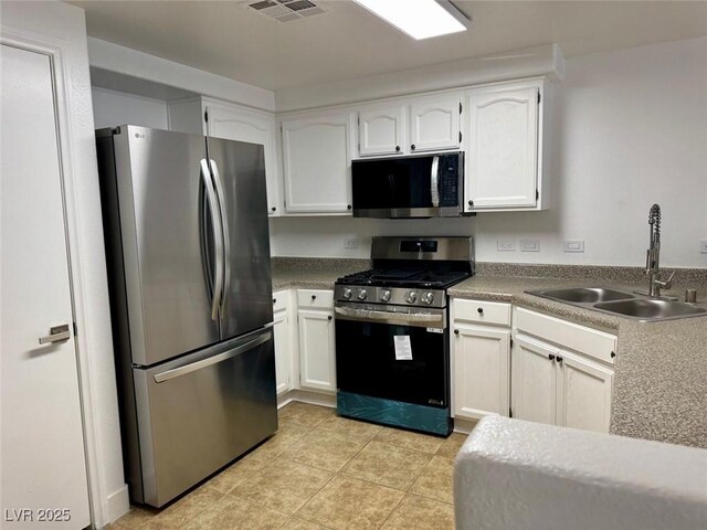 3400 Cabana Dr Unit 1033, Las Vegas, NV 89122 - kitchen featuring appliances with stainless steel finishes, a sink, white cabinetry, and light tile patterned floors