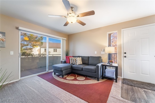 living area featuring baseboards, a ceiling fan, and wood finished floors