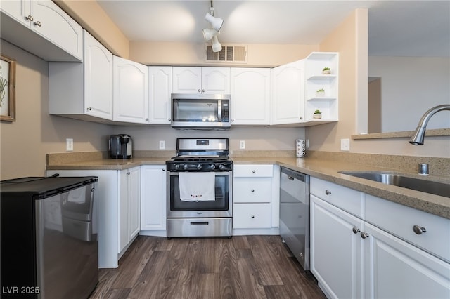 kitchen featuring a sink, stainless steel appliances, open shelves, visible vents, and white cabinets