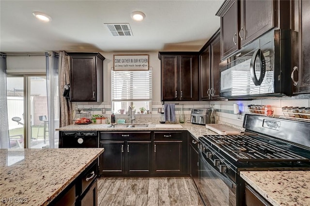 6231 Portland Treaty Ave, Las Vegas, NV 89122 - kitchen featuring a sink, light stone counters, black appliances, and visible vents